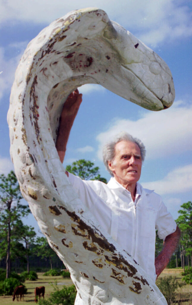 Man posing with a large cobra statue