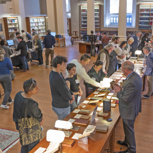 visitors and librarians looking at book and archive exhibits on a long table