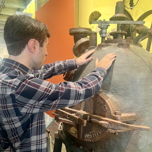 man touching a museum object with both hands