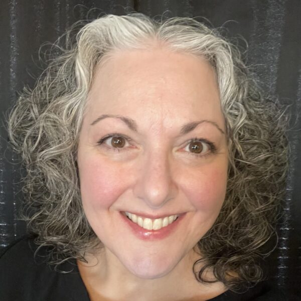 headshot of Dana Rodriguez, smiling, over a dark backdrop