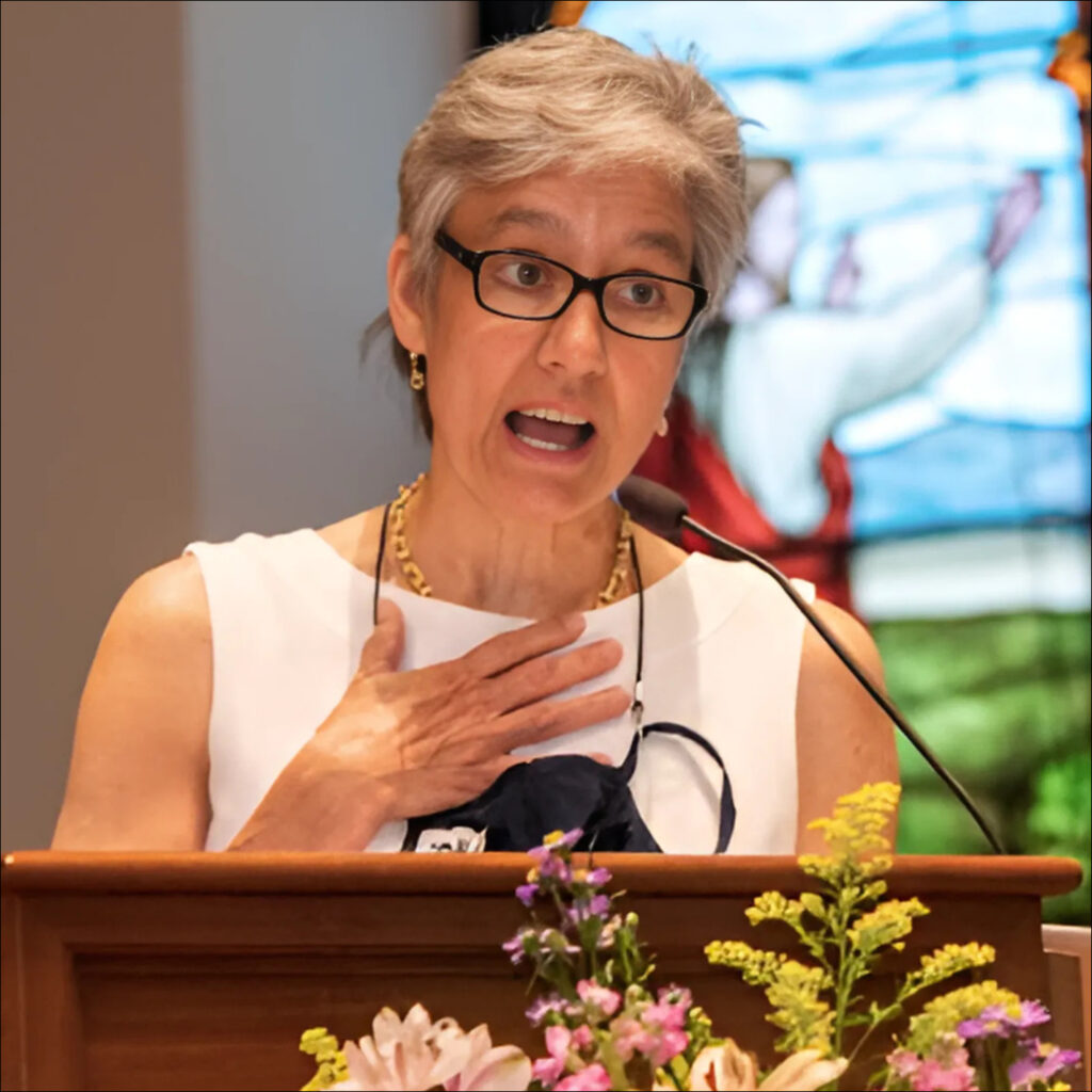 Peggy Prevoznik Heins speaking at a church podium