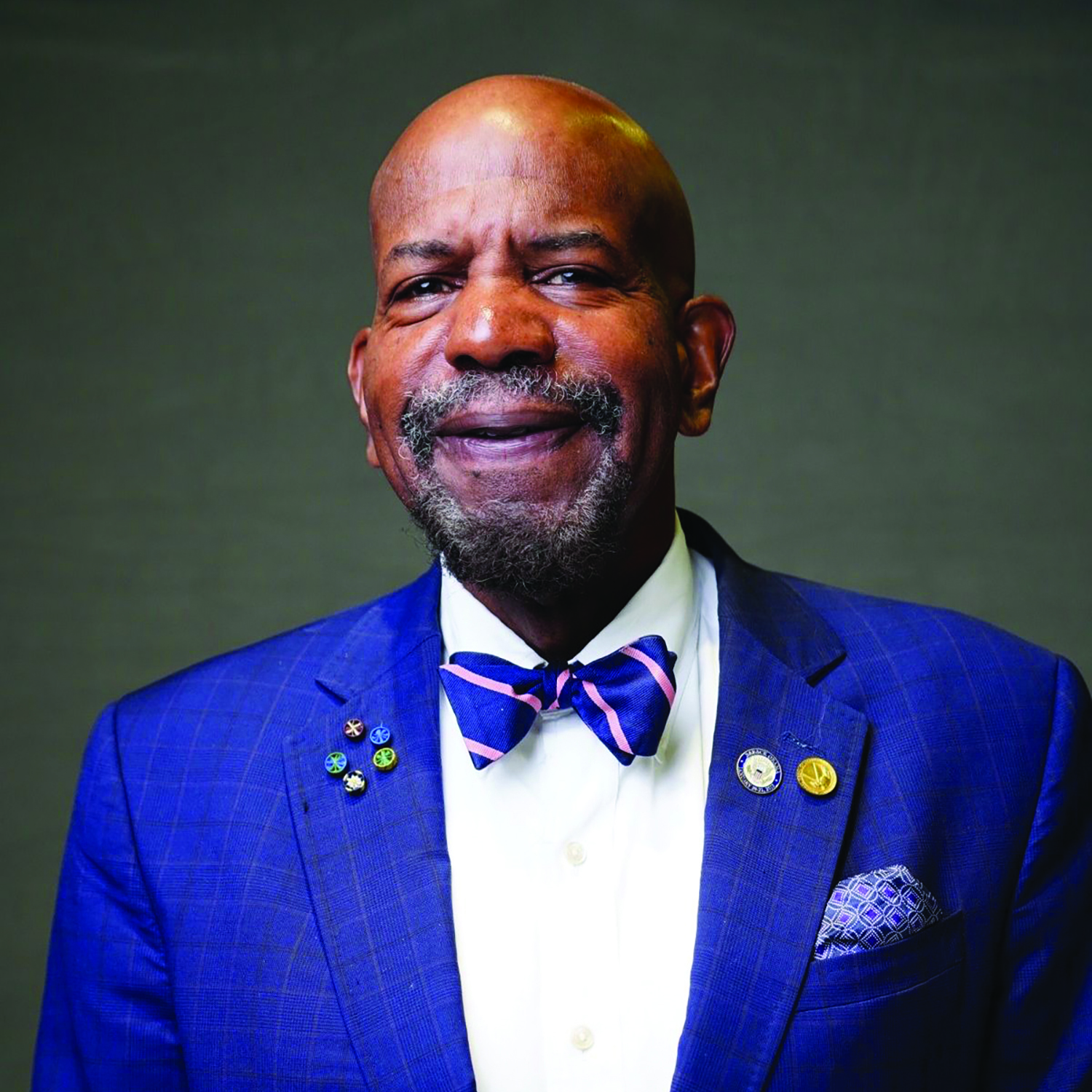 studio portrait of Sir Cato T. Laurencin wearing blue suit, white shirt, and blue patterned bowtie