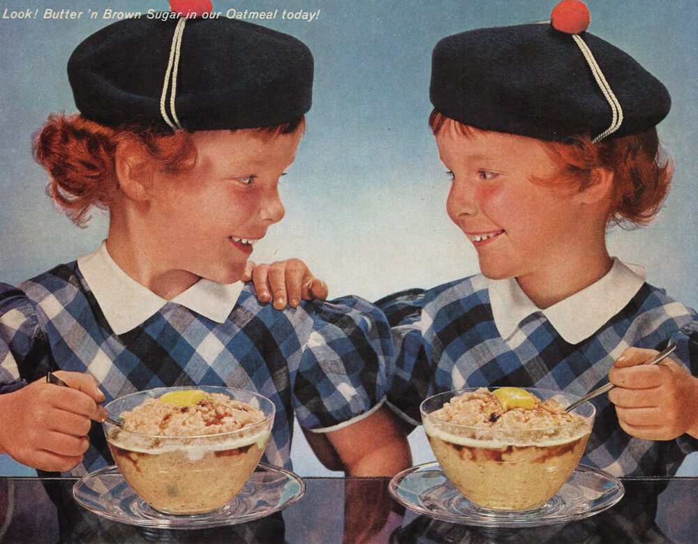 Twin girls in Scottish costumes eating bowls of oatmeal at a table