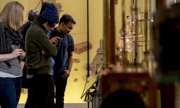 People observing exhibits in a museum setting.