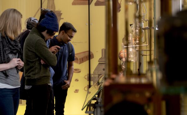 People observing exhibits in a museum setting.