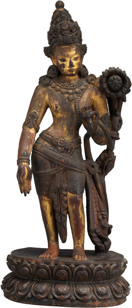 Wooden figure standing on a pedestal holding a lotus flower.