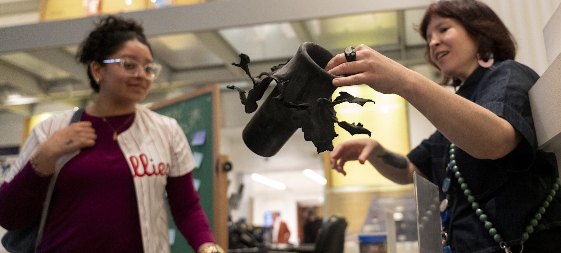 a museum educator explains what a flowerpot is to a fireworks exhibition visitor at the Science History Institute