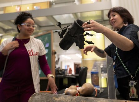 a museum educator explains what a flowerpot is to a fireworks exhibition visitor at the Science History Institute