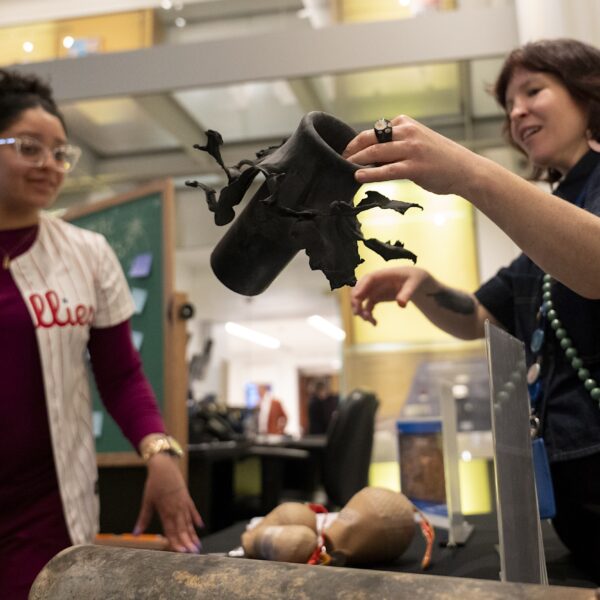 a museum educator explains what a flowerpot is to a fireworks exhibition visitor at the Science History Institute