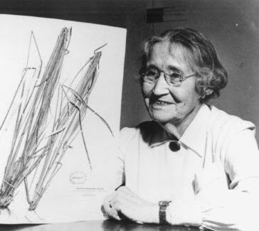 black and white of a women holding up a herbarium