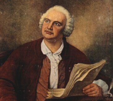 color portrait of a man seated holding a quill pen and paper