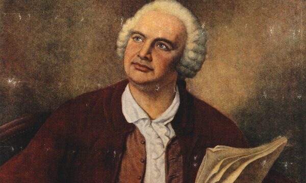 color portrait of a man seated holding a quill pen and paper