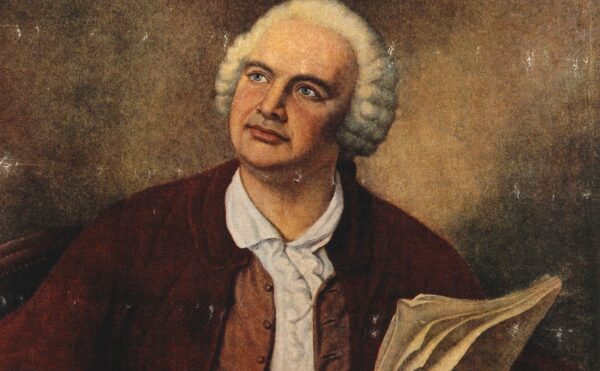 color portrait of a man seated holding a quill pen and paper