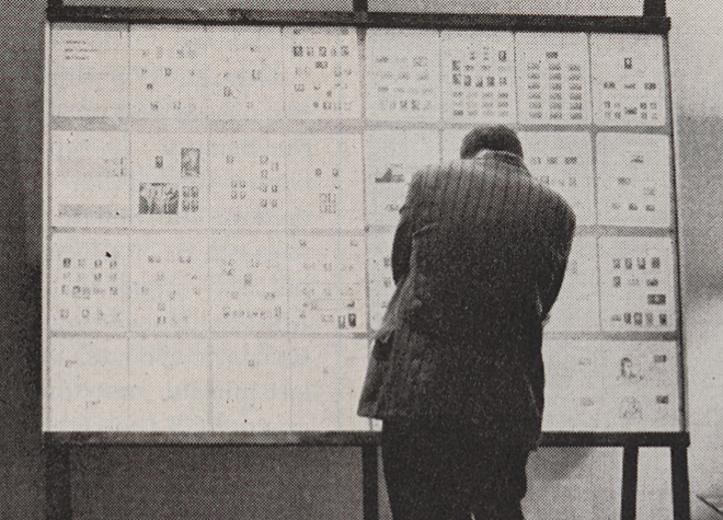 man standing in front of a display of botanical stamps