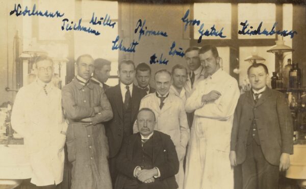 sepia-toned group photo of men in suits and lab coats