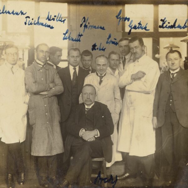 sepia-toned group photo of men in suits and lab coats