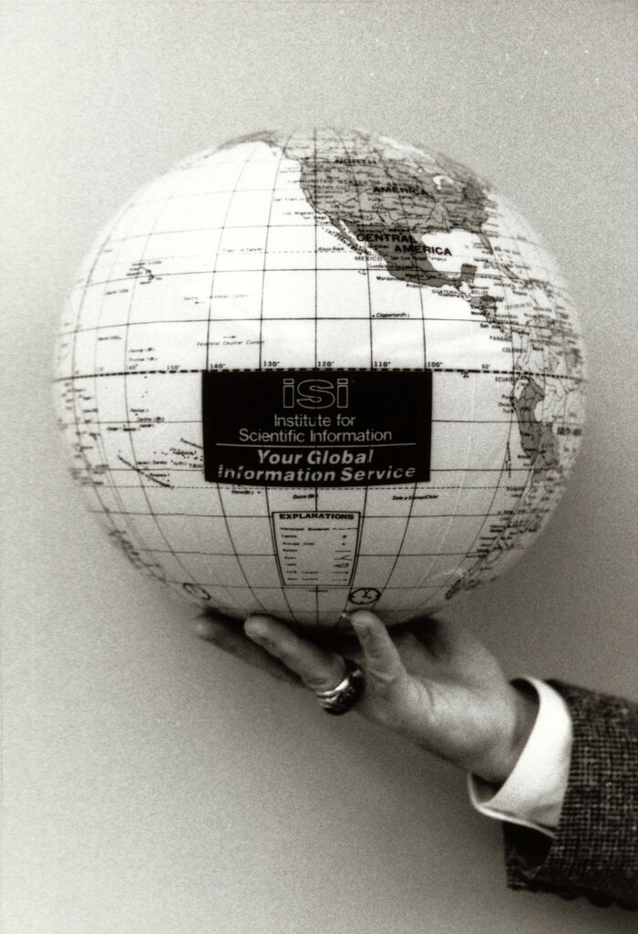 Hand holding a globe labeled “Institute for Scientific Information: Your Global Information Service.”