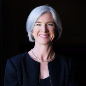 studio portrait, black background, of Jennifer Doudna wearing a navy blue suit