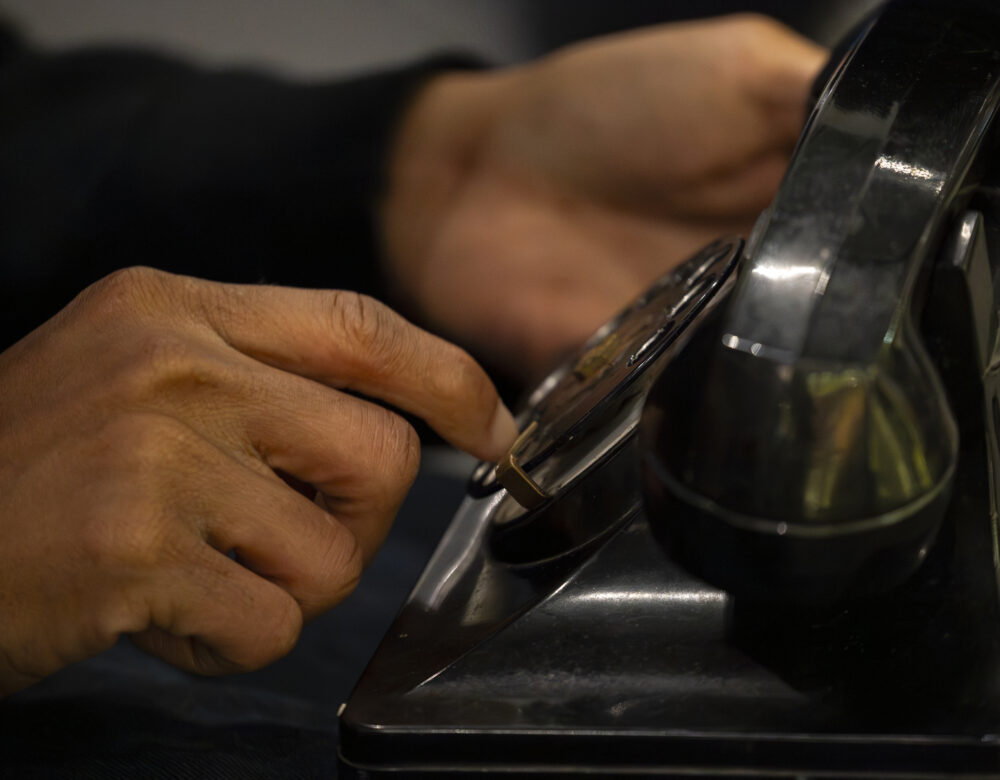 hands dialing a Bakelite rotary phone
