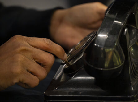 hands dialing a Bakelite rotary phone