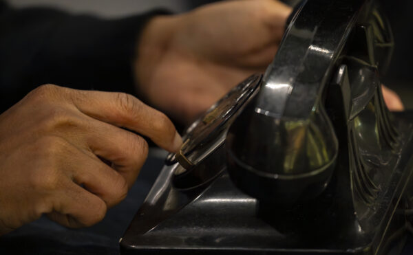 hands dialing a Bakelite rotary phone