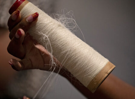 hand with manicured nails holding nylon thread in a spool