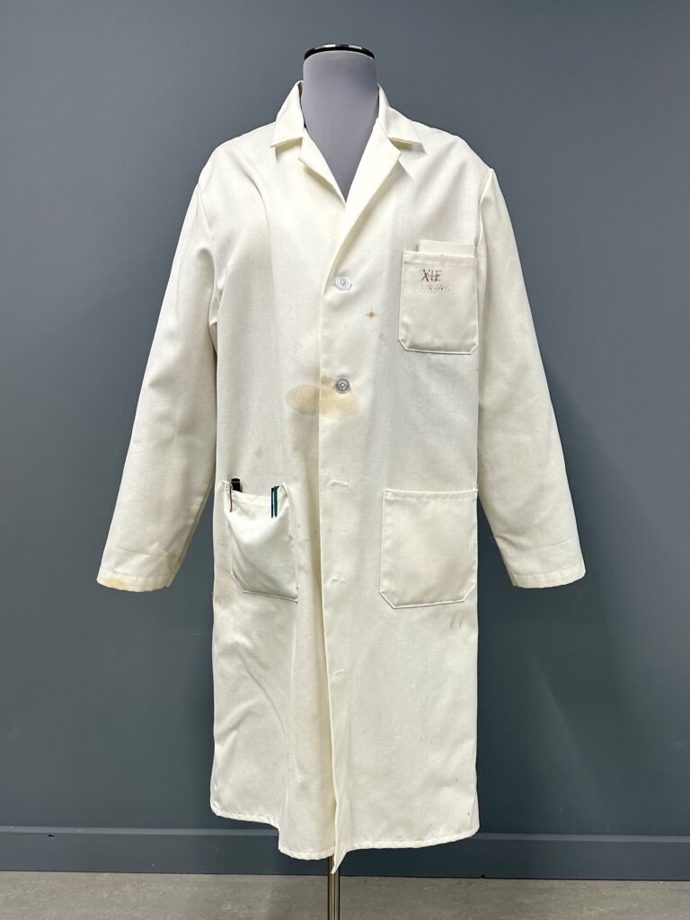 stained lab coat with pens in the left pocket