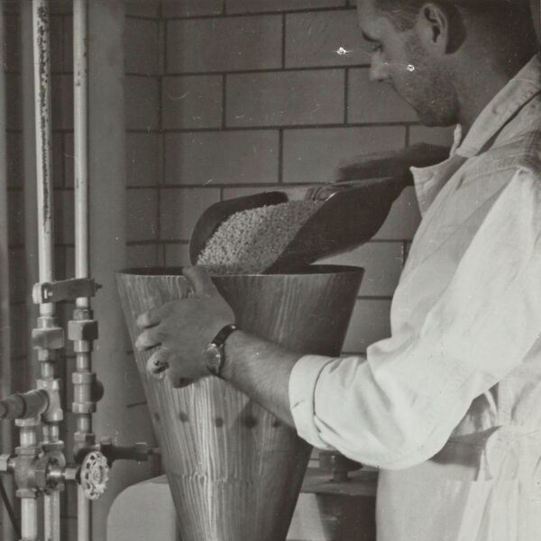 man pouring raw material into a funnel
