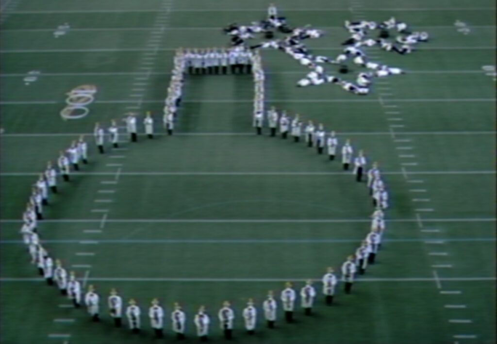 marching band dressed in lab coats performing on a football field