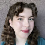 Rebecca Allen, turned slightly, in front of a gray wall