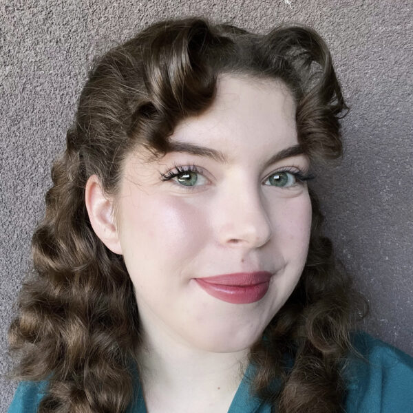 Rebecca Allen, turned slightly, in front of a gray wall