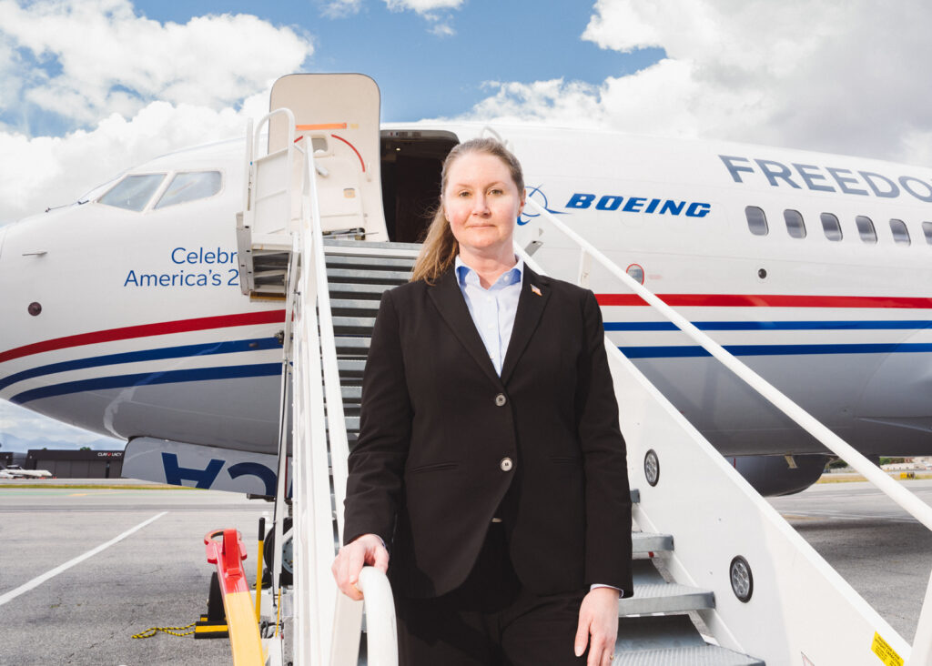 Pilot in uniform standing on tarmac before a jet plane