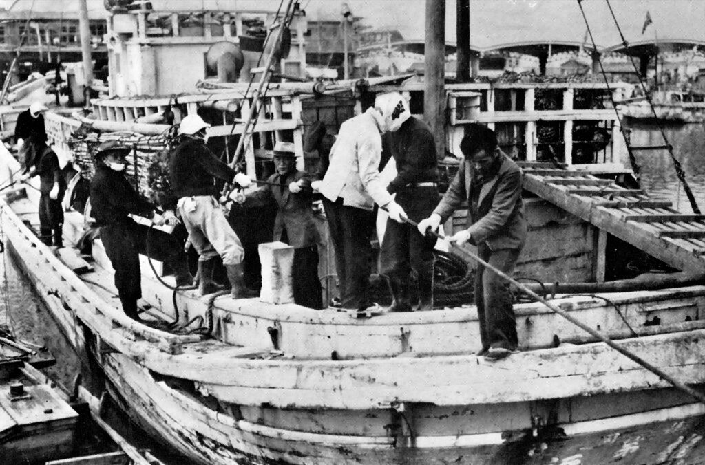 A group of men tugging ropes on a boat