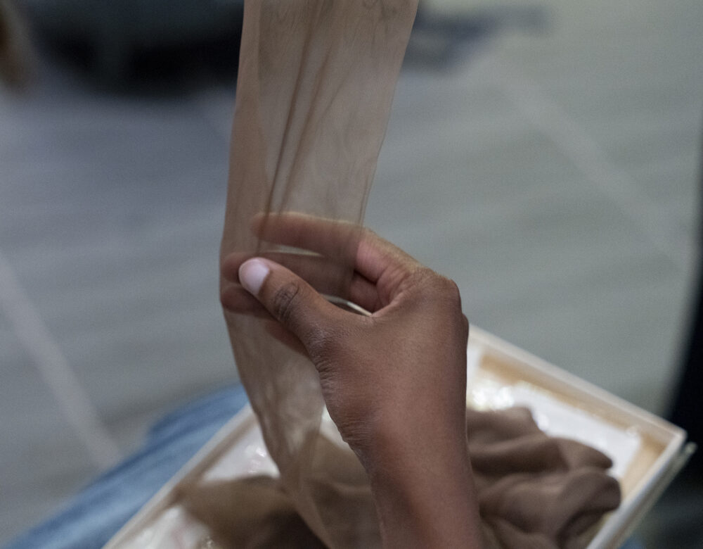right hand touching a nylon stocking