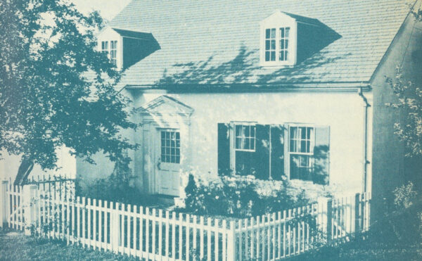 monochrome image of a home with picket fence