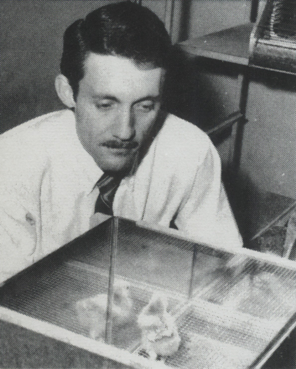 A man looking down at a chick in a box in a research setting