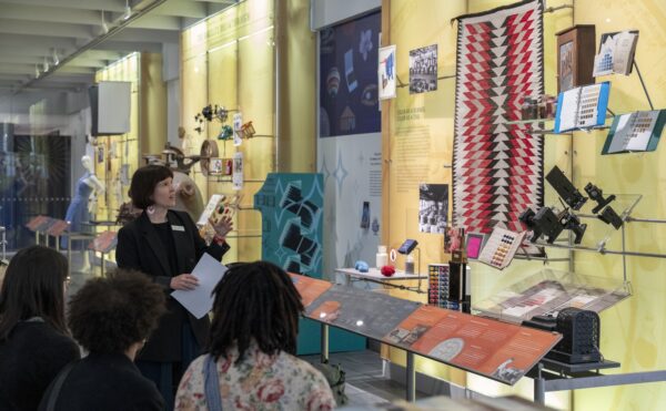 museum guide points out exhibits to visitors