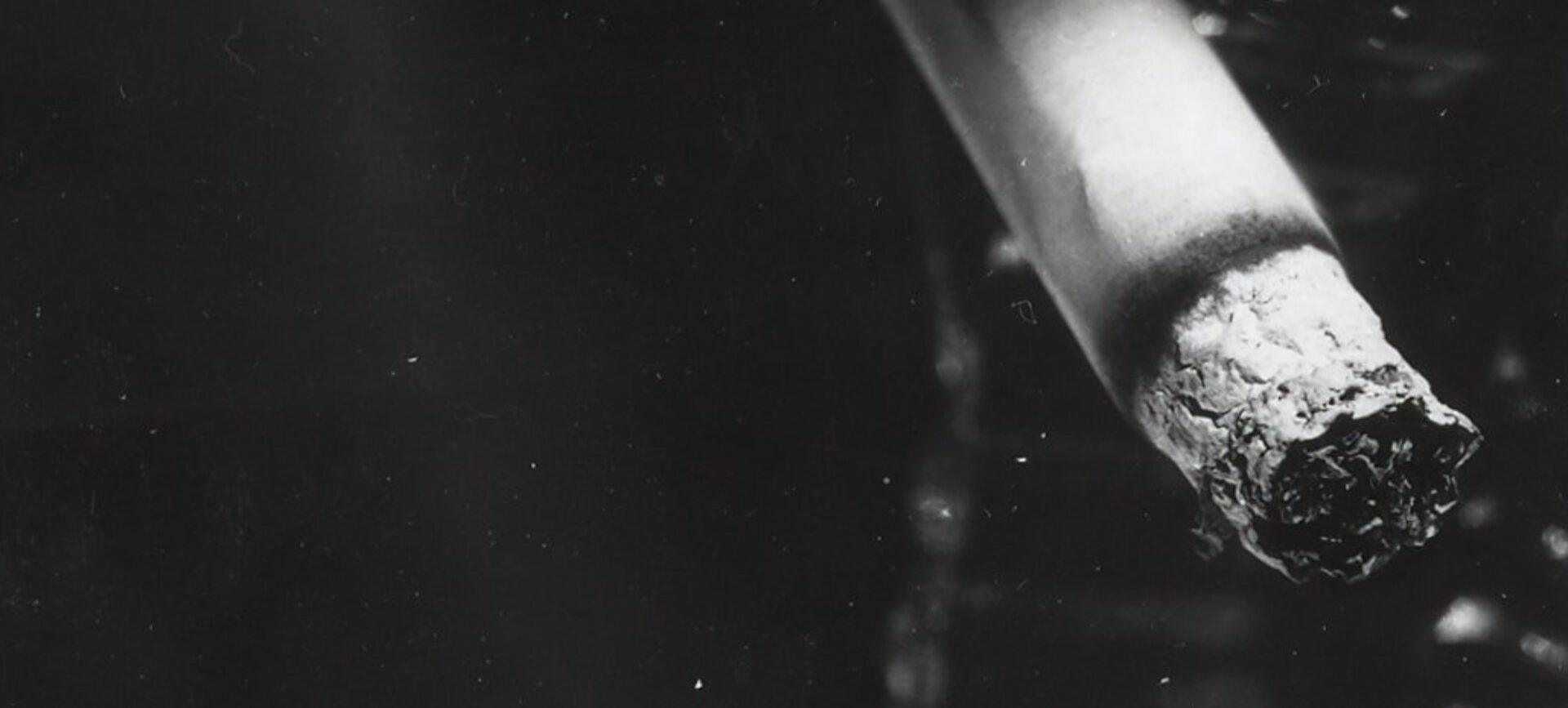 black and white photo of lit cigarette next to microchip