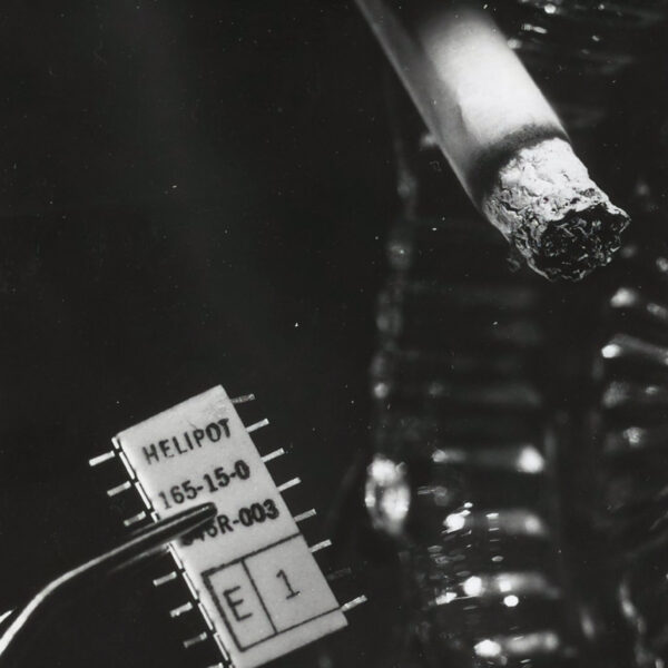 black and white photo of lit cigarette next to microchip