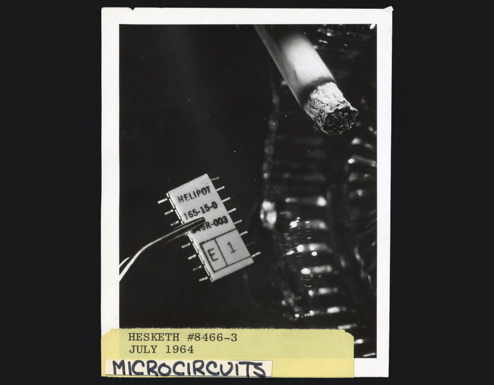 black and white photo of lit cigarette next to microchip