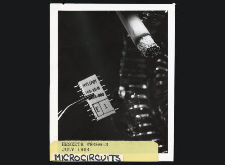 black and white photo of lit cigarette next to microchip