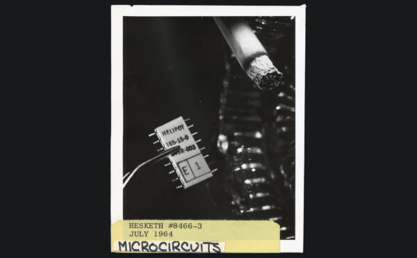black and white photo of lit cigarette next to microchip