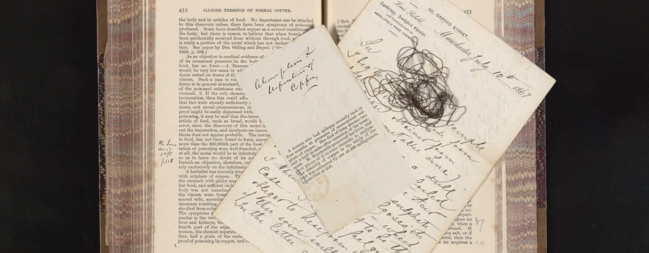 old book with newspaper clipping, wire, and handwritten notes on top of pages