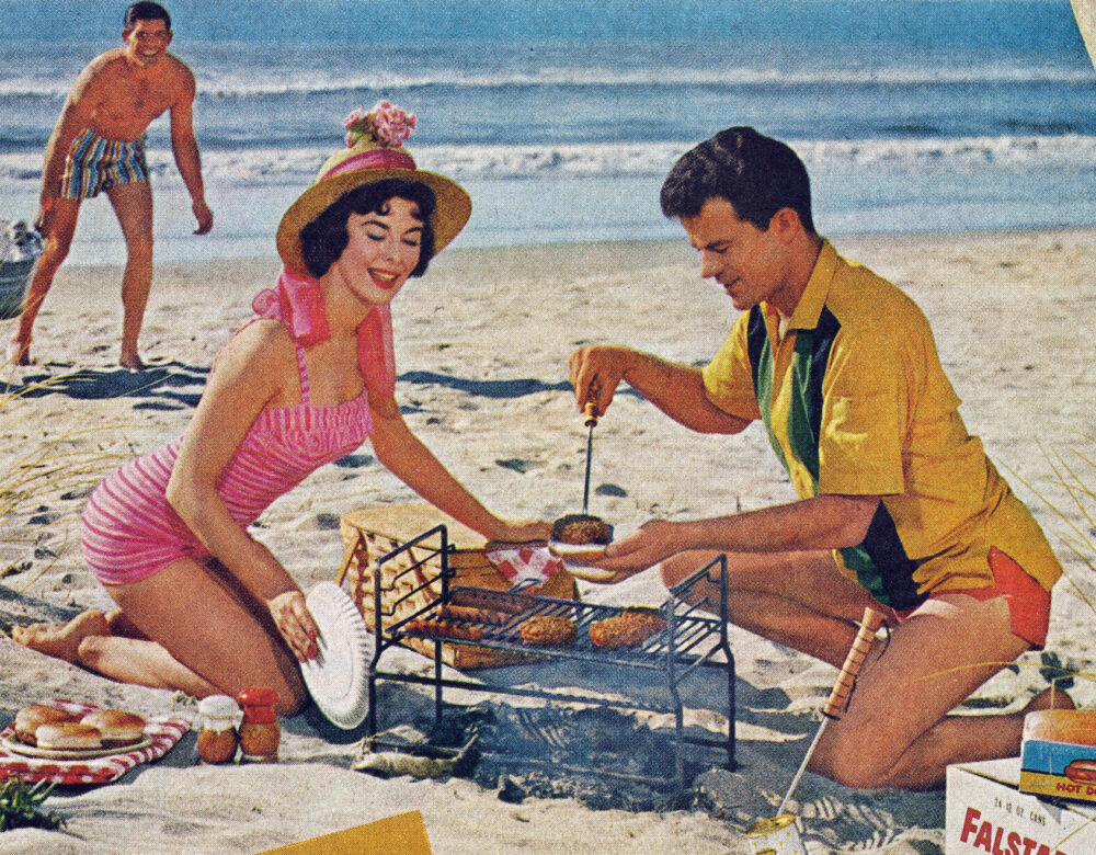 Advertising photo of a man and woman grilling on a beach