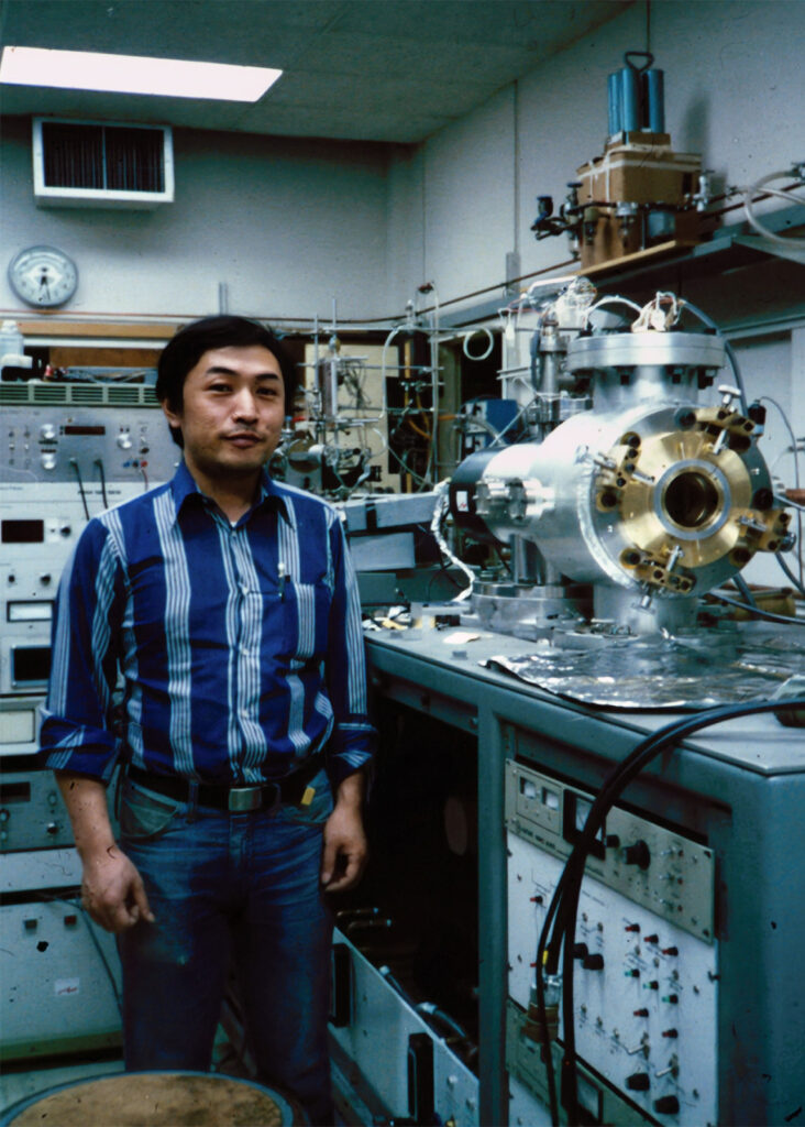 A man standing next to a machine in a laboratory.