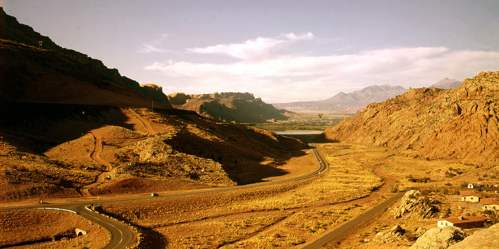 A road snaking through two mountains of reddish-brown rock.