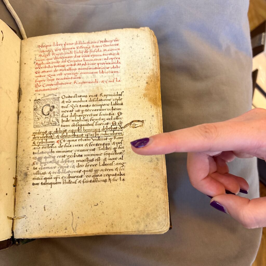 a finger pointing at a page in an old book