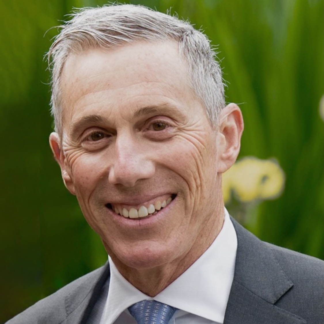 photo of a man with gray hair wearing a suit and smiling