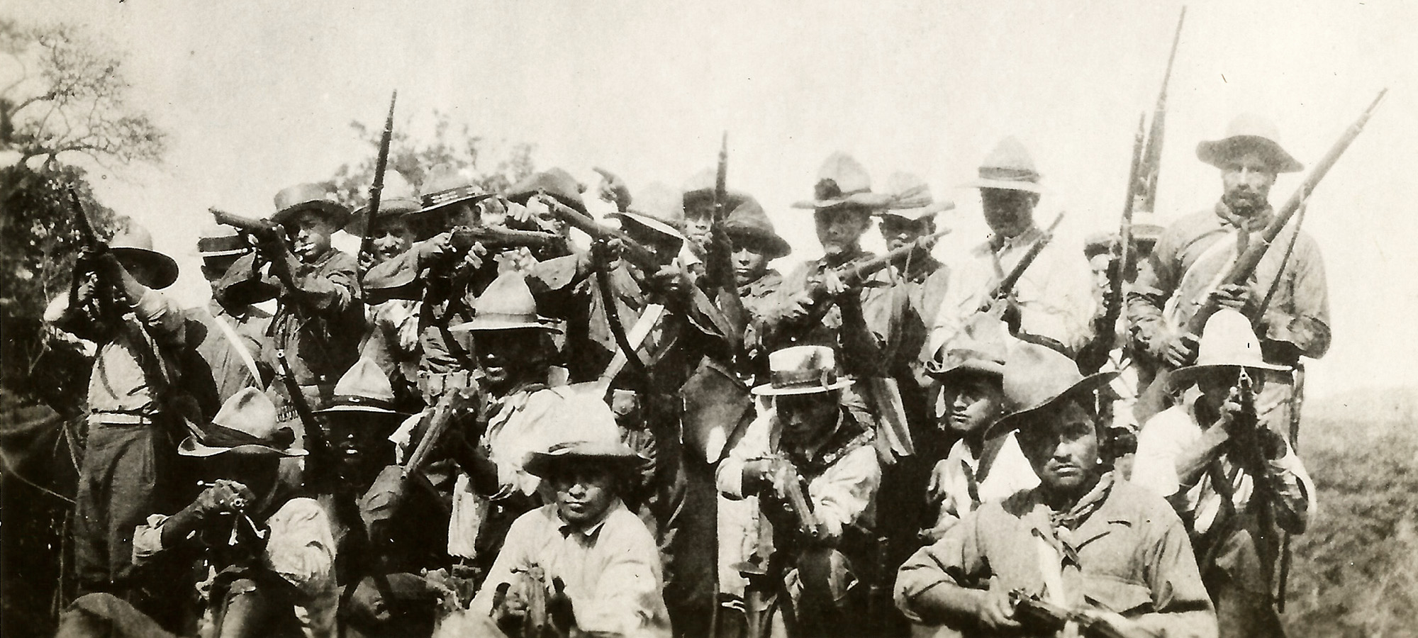 A group of men holding guns posing for a photograph.