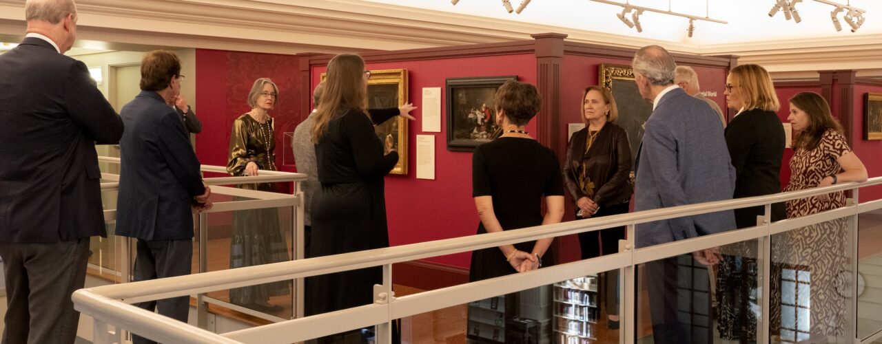 People gathered in a museum looking at paintings
